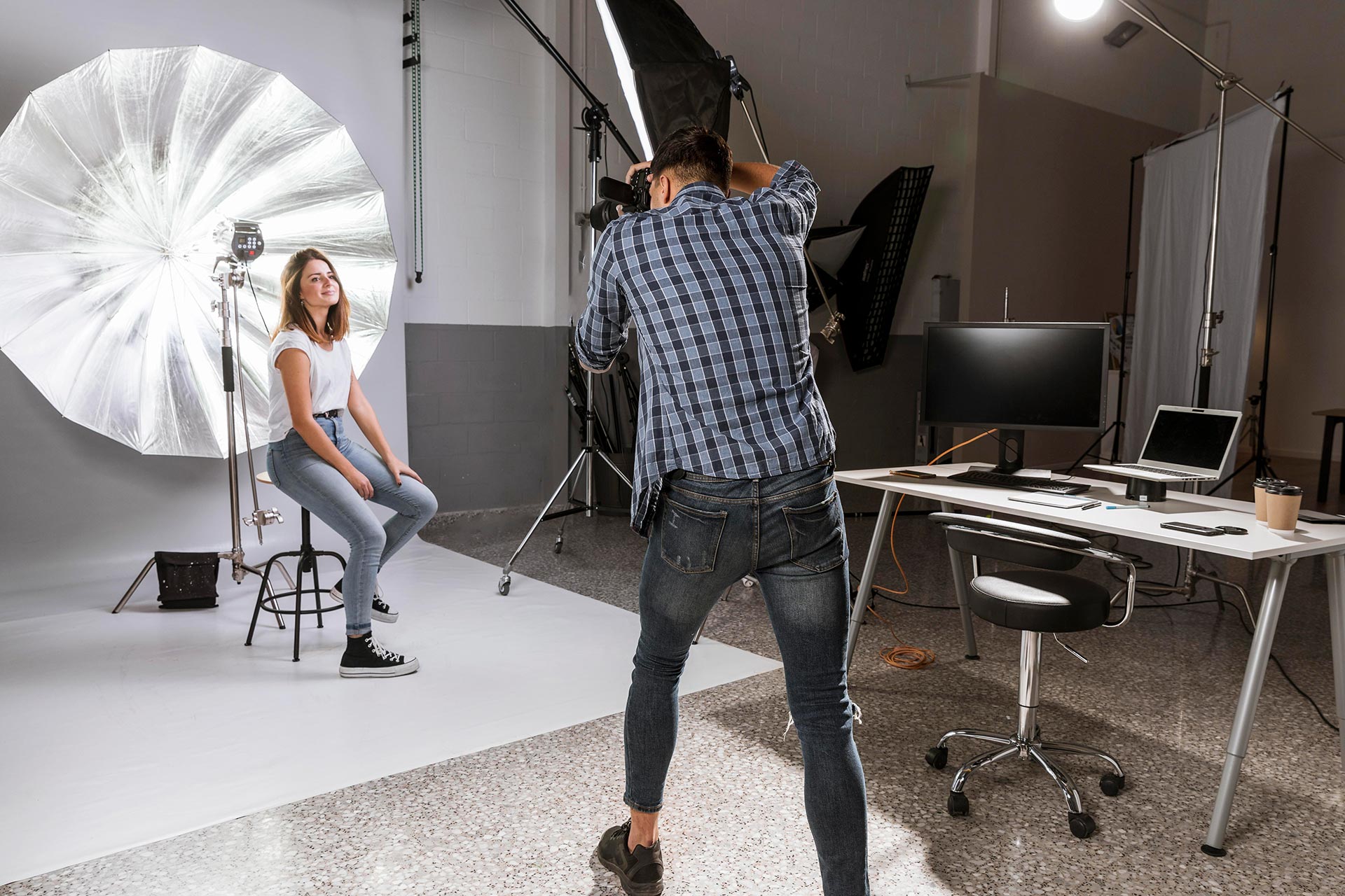 Photographer clicking photographs of his model in a studio.